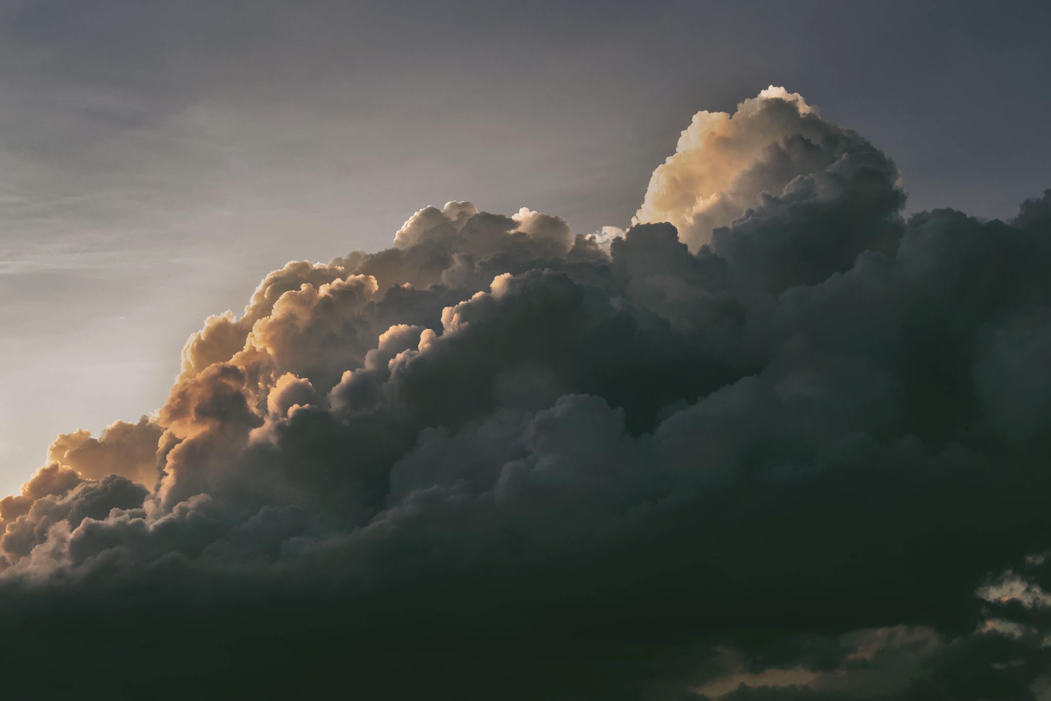 A beautiful and dramatic cloudscape with warm sunlight peeking through at twilight, creating a serene sky.